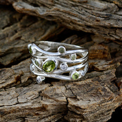 Rebeca multicolor gemstone statement ring with green gemstones set in silver band on wood background