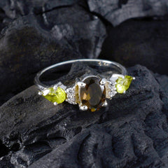 Naomi multicolor gemstone trilogy ring with a central brown oval stone and two yellow-green side stones on silver band