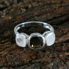 Isla multicolor gemstone trilogy ring with three distinct stones set in silver band on textured bark