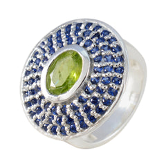 Putri multicolor halo cocktail ring with oval green center gemstone surrounded by blue pave stones on silver band