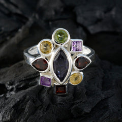 Luna multicolor navratna ring with various gemstones set in silver band on dark textured background