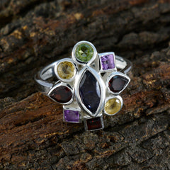 Luna multicolor navratna ring with various gemstones set in silver band on textured wood background