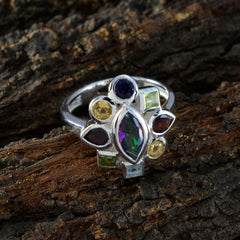 Mathilde multicolor navratna ring with various gemstones set in silver band on rustic wood