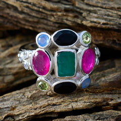Lorena multicolor Navratna ring with vibrant gemstones set in silver on rustic wooden background