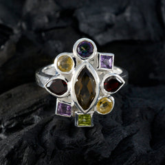 Araya multicolor navratna ring with various gemstones set in silver band on dark background