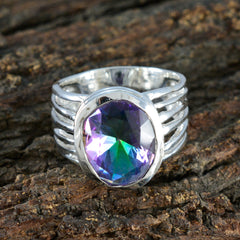 Eliza multicolor solitaire ring with oval faceted mystic topaz in split silver band on wood