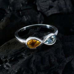 Jia multicolor toi et moi ring with yellow and blue gemstones in silver setting on black textured surface