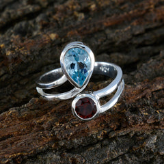 Siti multicolor toi et moi ring silver open band with pear blue topaz and round red garnet on wood background