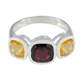 Milagros multicolor trilogy ring with a central deep red gemstone flanked by two yellow gemstones in silver setting