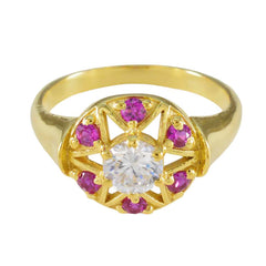 Jiwoo Navratna engagement ring with gold band, central clear gemstone, and pink stones surrounding it