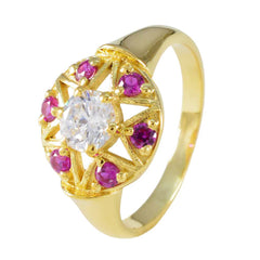 Jiwoo Navratna engagement ring with gold band and center clear stone surrounded by red gemstones