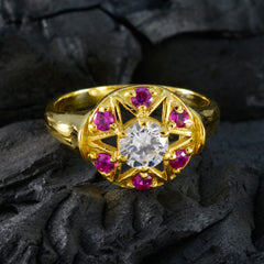 Jiwoo Navratna engagement ring with central clear gemstone and surrounding pink stones in gold setting