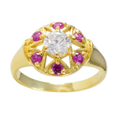 Jiwoo Navratna engagement ring with central diamond and surrounding pink gemstones in gold setting