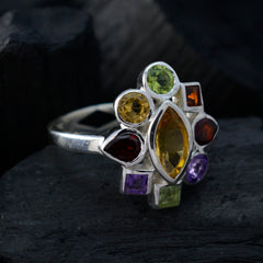 Maya navratna gemstone ring in sterling silver with multicolored gemstones arranged in floral cluster on dark background