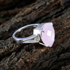 Tereza pink solitaire engagement ring with silver band on textured wood surface