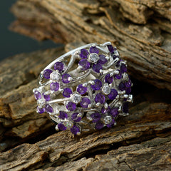 Isadora purple floral gemstone ring in sterling silver with clustered amethyst petals and diamond accents on rustic wood