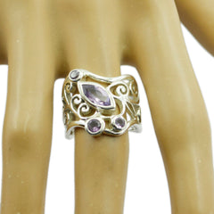 Nisa purple gemstone filigree ring with intricate silver swirls on a display hand