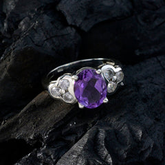 Harper silver ring with a vibrant purple gemstone ring center and clear side stones on dark textured surface