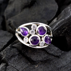 Katarina silver purple gemstone ring with multiple round and teardrop purple stones on black stone background