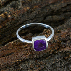 Lakshmi purple gemstone solitaire ring with silver band on rustic wood background