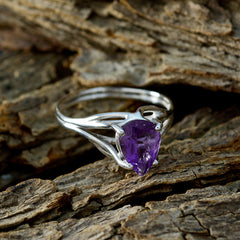 Seo-yeon purple gemstone solitaire ring with pear-shaped stone and silver band on rustic wood