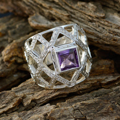 Aurora purple gemstone statement ring with geometric silver lattice design on rustic wood