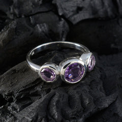 Ying silver purple gemstone trilogy ring with three faceted amethyst stones on black textured background