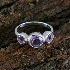 Ying silver ring with three purple gemstones set in a purple gemstone trilogy ring design on rustic wood