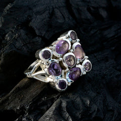Nia purple navratna ring with multiple purple gemstones set in silver band on dark background