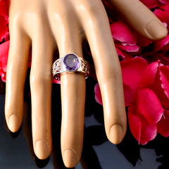Bianca purple solitaire gemstone ring with a silver band displayed on a hand model with red petals background