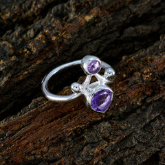 Renata purple toi et moi ring with two purple gemstones set in silver band on textured bark