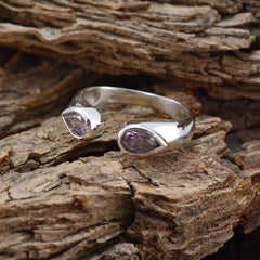 Silver Mila purple toi et moi ring with two pear shaped purple gemstones in bezel setting on rustic bark background
