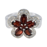 Isla red floral gemstone ring with five petal design and clear accent stones on silver band