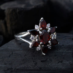 Lorena red floral gemstone ring on silver band featuring marquise and oval red stones with small clear accents