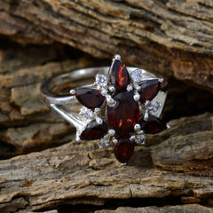 Lorena red floral gemstone ring sterling silver cluster with garnet petals and accent stones on wood background