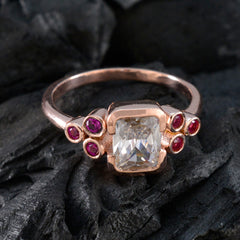 Florencia red gemstone hepta ring rose gold band with central emerald cut clear stone and six small red gems