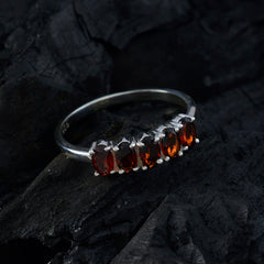 Xiu red gemstone ring for women with five oval red stones set in sterling silver band on dark stone background