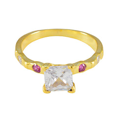 Saanvi gold ring featuring a clear center stone and small red gemstones red gemstone ring for women