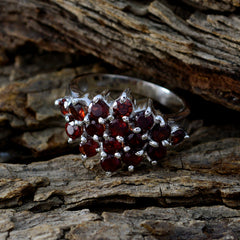 Saanvi red gemstone statement ring with multiple deep red stones set in silver band on rustic wood