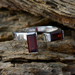 Hua red gemstone toi et moi ring with rectangular red stones on silver band on textured wood