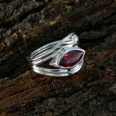 Teresa red gemstone toi et moi ring with marquise red stone and silver twisted band on bark background
