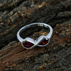 Tereza red gemstone toi et moi ring with silver infinity design on textured wood background
