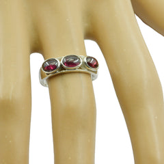 Chen red gemstone trilogy ring featuring three oval red stones set in silver band on finger
