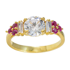 Araya red halo gemstone ring with round clear center stone and red accent gemstones on gold band