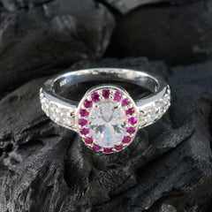 Ivana red halo ring for women with oval clear center stone and small red gemstones around it on silver band