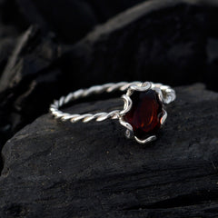 Wen elegant red solitaire gemstone ring with twisted silver band on dark textured surface