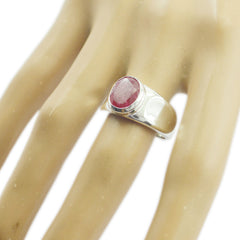 Nisa red solitaire gemstone ring with oval red stone set in polished silver band on hand