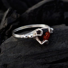 Ella red solitaire gemstone ring with silver band and intricate prong setting on dark background