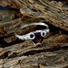 Ella red solitaire gemstone ring with silver band and triangular red stone on rustic wood background