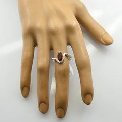 Emi red solitaire ring with marquise red gemstone set in silver band on mannequin hand